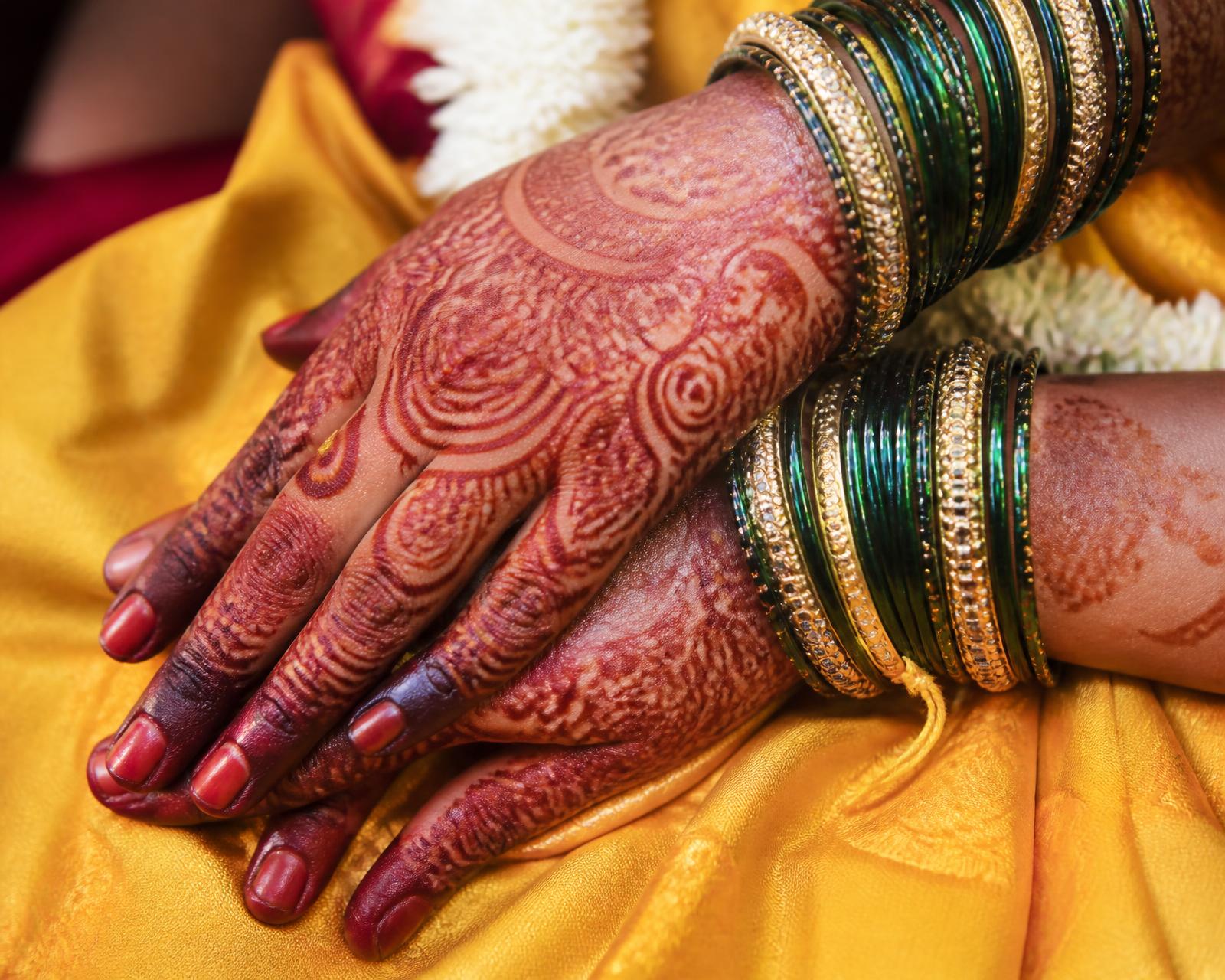 Bridal mehndi and glass bangles on a bride's hands